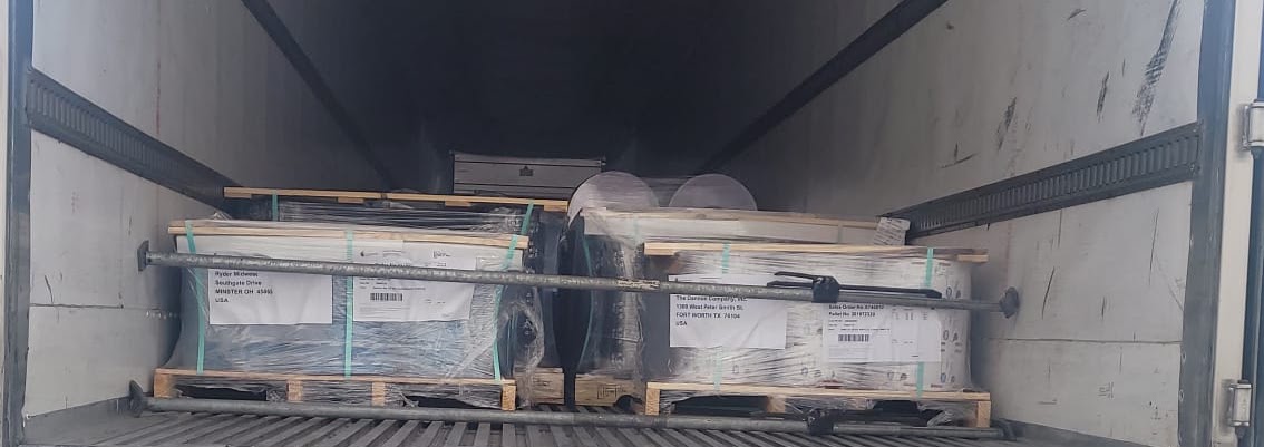 Shrink-wrapped pallets secured with load bars inside a trailer